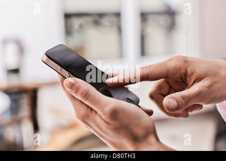 In prossimità di una donna mano utilizzando nero cellulare Foto Stock