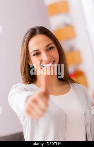 Immagine luminosa della giovane donna con il pollice in alto Foto Stock