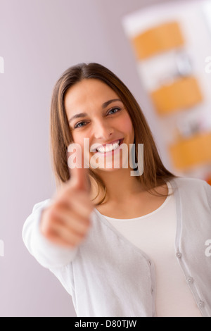 Immagine luminosa della giovane donna con il pollice in alto Foto Stock