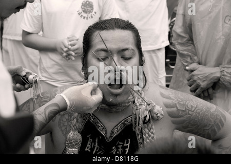 PHUKET, Tailandia 3 Ottobre 2011: una media di spirito ha il suo volto trafitto presso il Phuket annuale Festival vegetariano. Foto Stock