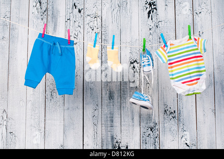 Baby vestiti appesi al stendibiancheria. Foto Stock