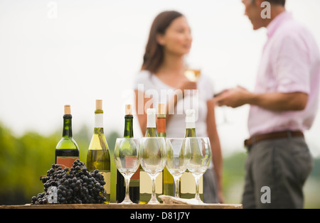 Bottiglia di vino, uva e i bicchieri sul tavolo all'aperto Foto Stock