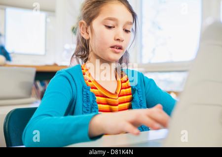 Ragazza caucasica utilizzando laptop in biblioteca Foto Stock