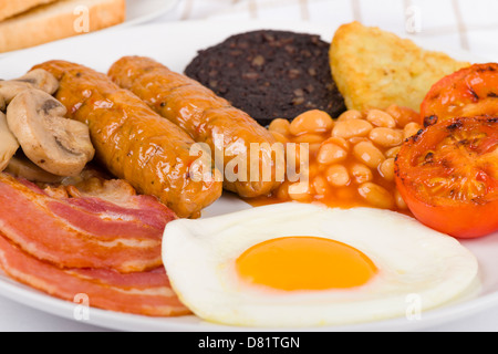 La completa prima colazione inglese - il fritto con uova, bacon, funghi, pomodori, salsicce, budino nero, hash browns e fagioli al forno. Foto Stock