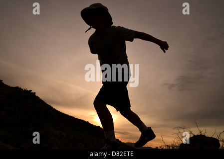 Boys jump massi durante le escursioni ai piedi delle colline di Santa Catalina Mountains, Deserto Sonoran, Catalina, Arizona, Stati Uniti. Foto Stock