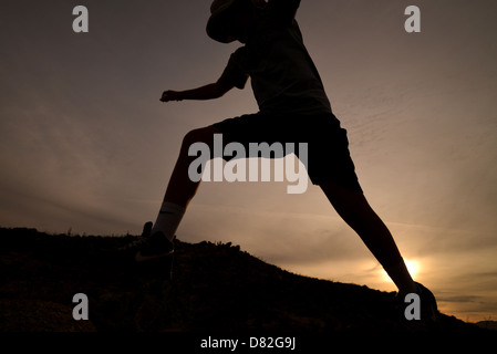 Boys jump massi durante le escursioni ai piedi delle colline di Santa Catalina Mountains, Deserto Sonoran, Catalina, Arizona, Stati Uniti. Foto Stock