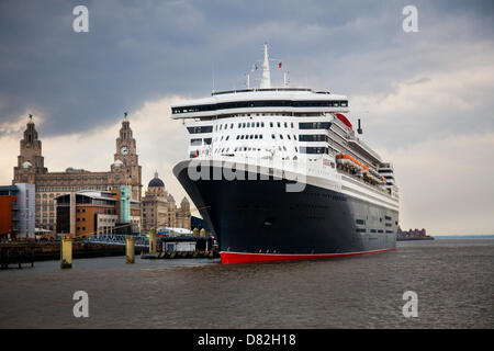 Liverpool, Regno Unito il 17 maggio 2013. La grande nave da crociera terminale in cui la nave passeggeri registrati in Bermuda Liner RMS Queen Mary 2 ormeggiato sulla sua visita alla città. Il Liverpool Cruise Terminal è un 350-metro-lunga struttura galleggiante situato sul fiume Mersey consentendo grandi navi da crociera per visitare senza inserire il dock chiuso o sistema di ormeggio a metà fiume e i passeggeri di gara a terra. Il terminale è stato ufficialmente inaugurato il 21 Settembre 2007 da Sua Altezza Reale il Duca di Kent quando la Queen Elizabeth 2 ormeggiato al Prince's Dock terminale. Foto Stock