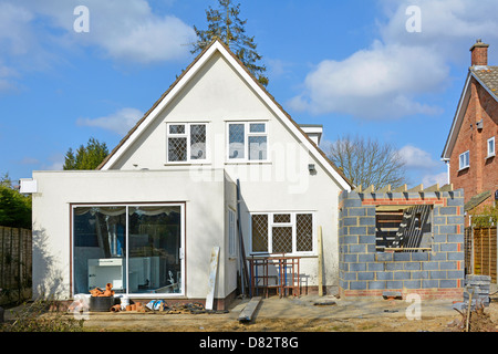 Lavori di costruzione a lato della casa indipendente per aggiungere due piani di camera da letto e cucina estensione visto dal retro del giardino England Regno Unito vedere 'More Info' nota di seguito Foto Stock