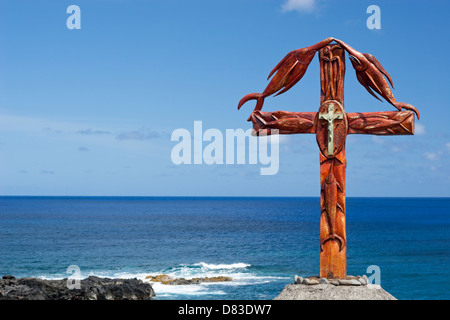 Fisherman's Memorial, una croce cristiana in legno decorata con pesci intagliati che si affaccia sulla costa dell'isola di Pasqua Foto Stock