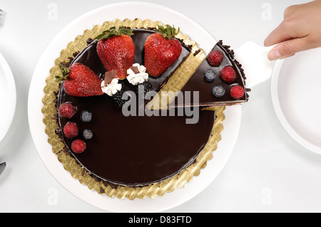 Donna che serve una torta al cioccolato Foto Stock