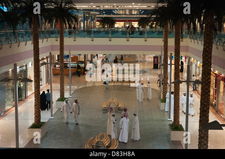 Arabi del Golfo gli uomini indossano abiti nazionali come la passeggiata attraverso il Centro Commerciale Marina di Abu Dhabi, Emirati arabi uniti Foto Stock