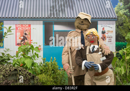 Londra, Regno Unito. Il 18 maggio 2013. Semina e la sua costruzione il lavoro continua per il Chelsea Flower Show 2013 prima della sua apertura la prossima settimana. Immagine: Generazione giardini con scarecrows fatto dalla scuola i bambini. Miracolo Gro'wers 1940's giardino. Foto: Nick Savage/Alamy Live News Foto Stock