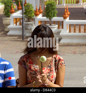 PHUKET, Thailandia 15 MAGGIO 2013: tailandese donna offre incenso e abbassare mentre Wat Chalong Foto Stock