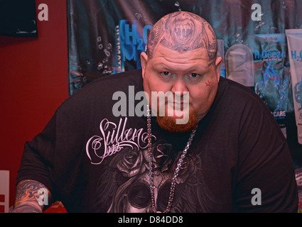 Un uomo con più per viso e testa di tatuaggi al 16th Annual New York City Tattoo Convention di Manhattan. Foto Stock