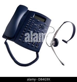 Telefono ufficio e le cuffie con microfono su sfondo bianco Foto Stock