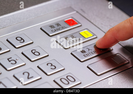 Mano immettendo il numero di identificazione personale su ATM pannello di composizione Foto Stock