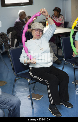 Dei cittadini anziani in un esercizio di classe a un senior center su Manhattan lower east side. Foto Stock