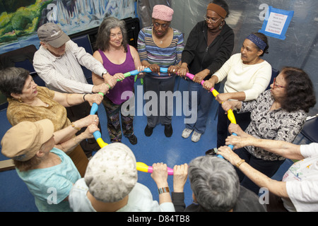 Dei cittadini anziani in un esercizio di classe a un senior center su Manhattan lower east side. Foto Stock