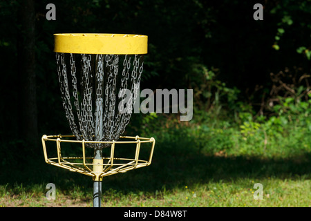 Un singolo disco golf (frisbee golf) permanente obiettivo di metallo bersaglio in una soleggiata apertura nel bosco. Foto Stock