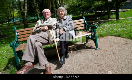 Una coppia di anziani godendo il sole di maggio nella primavera del Cardiff Bute Park Wales UK KATHY DEWITT Foto Stock