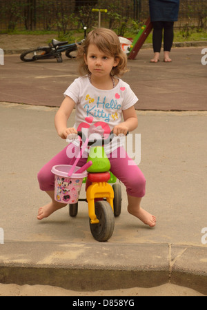 4 anno di età bambina sul triciclo sul parco giochi Foto Stock