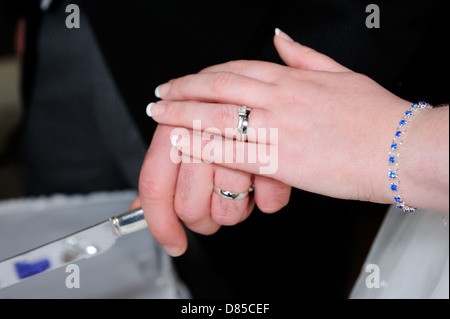 Primo piano della sposa e sposi mani torta di taglio Foto Stock
