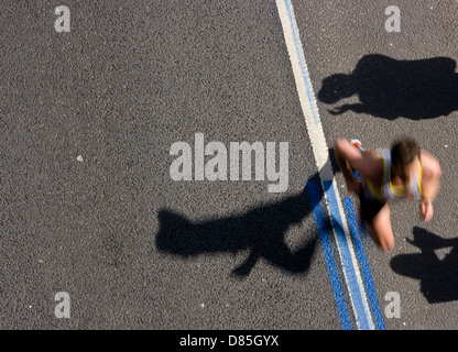 Il maratoneta motion blur e ombre silhouette di spettatori ad applaudire Foto Stock