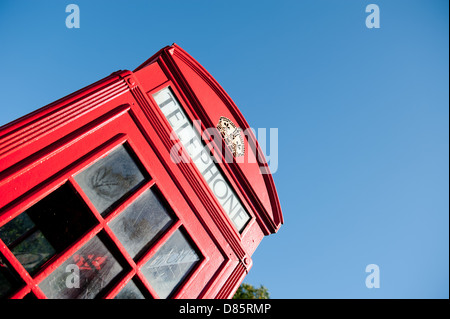 Vecchio stile Britannico rosso nella casella Telefono contro un cielo blu chiaro. Foto Stock