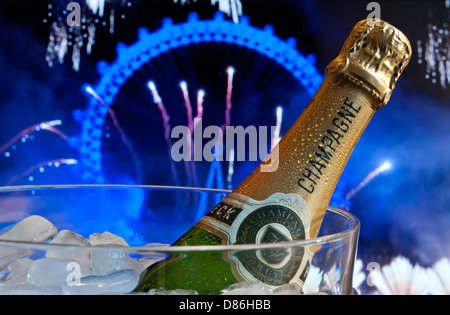 Bottiglia di champagne su ghiaccio in wine cooler con il London Eye dietro di notte con grandi feste fuochi d'artificio Foto Stock