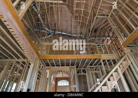 Montanti in legno per il framing Two-Storey Home con alto soffitto in soggiorno con scala interna Foto Stock