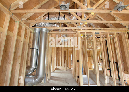 Nuova costruzione in casa con montanti in legno riscaldamento Framing sistema di raffreddamento condotto aria opere idrauliche ed elettriche di luce a soffitto lattine Foto Stock