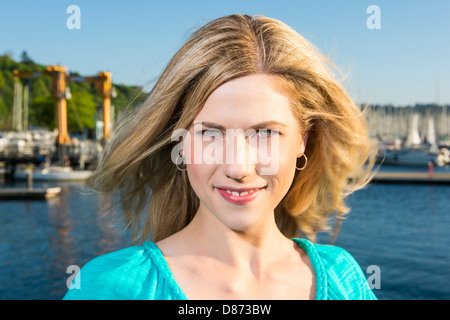 Ritratto della bella ragazza bionda con lo sfondo del porto Foto Stock