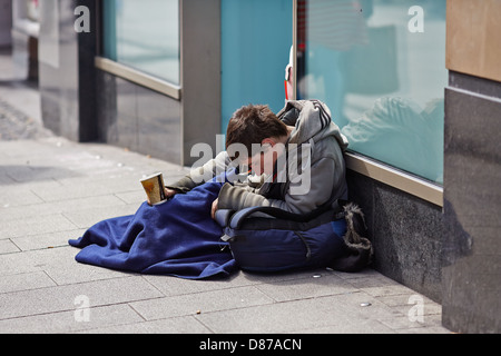 La persona senza dimora avvolto in un sacco a pelo nella zona dello shopping di Mary Street, Dublin city durante la recessione economica Foto Stock