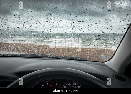 British seaside beach in un giorno di pioggia attraverso il parabrezza auto / parabrezza Foto Stock