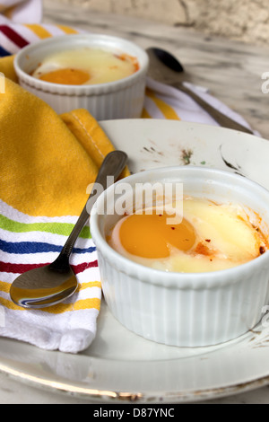 Uovo in ramekin con salsa di pomodoro e il chorizo non cotte. Foto verticale. Foto Stock