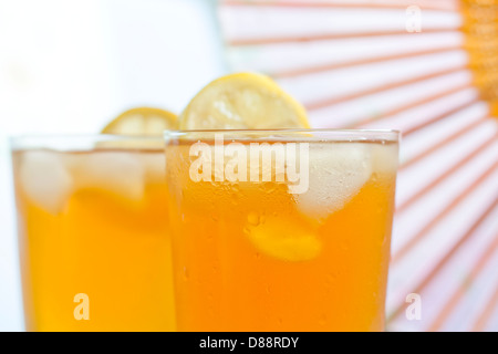 Bicchiere di tè freddo al limone su sfondo sfocato Foto Stock