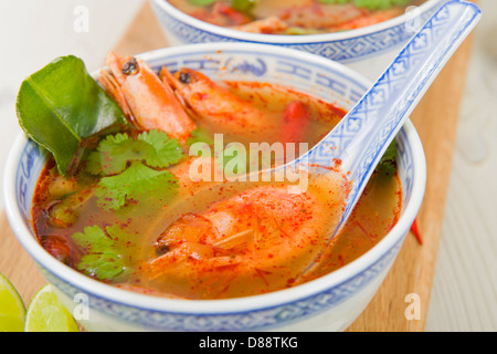 Tom Yum Goong - Thai chiara e calda zuppa acida con gamberoni e funghi Oyster servito con spicchi di lime. Foto Stock