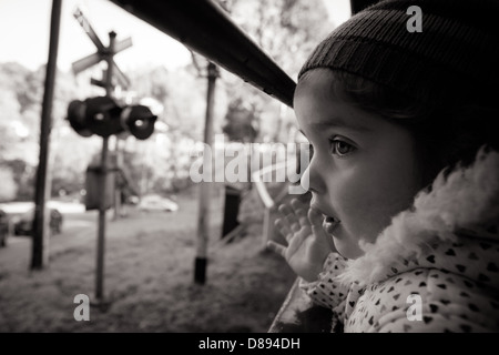 Una giovane ragazza guarda fuori da una finestra sul Treno a Vapore Puffing Billy a Melbourne, Victoria, Australia Foto Stock