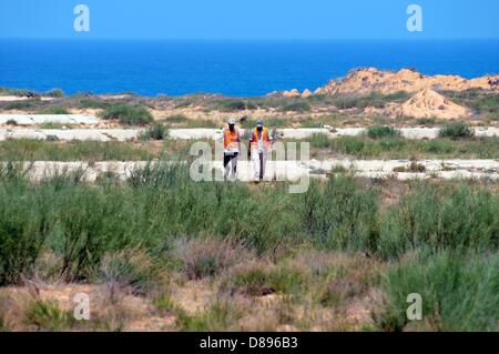 Due dipendenti del tedesco di Santa Barbara Foundation a piedi per una sicurezza speciale rifugio su di un terreno di esplosione, dove si impegnano nell'esplosione controllata di munizioni, vicino cioè Tripoli, Libia, 6 maggio 2013. I dipendenti del tedesco di Santa Barbara lavori di fondazione sulla demolizione controllata di armi e di esplosivi in questa zona. Fin dalla sua fondazione nel 1995, la Santa Barbara Foundation supporta il gioco da armi da fuoco ed esplosivi resti di ex aree di conflitto e teatri di guerra e fornisce aiuti umanitari. La ONG è attivo in Libia dall inizio del 2012 e finanziato tra gli altri per mezzo del germe Foto Stock