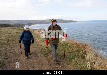 Il marito e la moglie a piedi lungo la strada di Cleveland vicino a Ravenscar, North York Moors, England Regno Unito Foto Stock