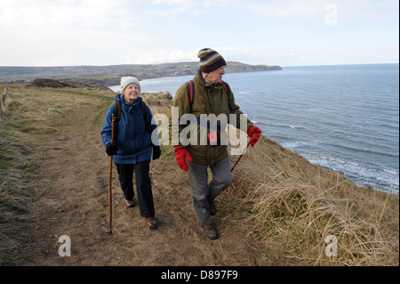 Il marito e la moglie a piedi lungo la strada di Cleveland vicino a Ravenscar, North York Moors, England Regno Unito Foto Stock