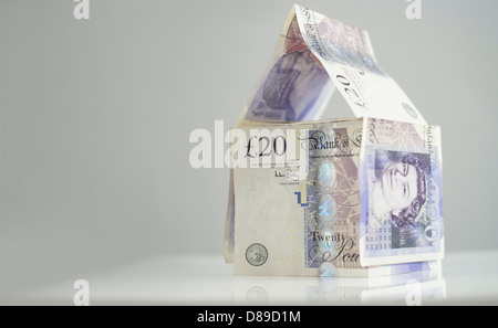 Gli investimenti immobiliari. Una casa fatta di venti pound note. Foto Stock