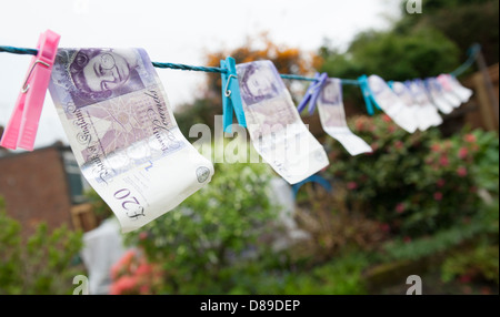 Una linea di venti Pound note essiccamento su una linea. Foto Stock