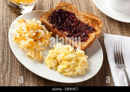 In casa ricca colazione americana con uova, toast, hashbrowns Foto Stock