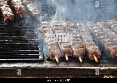 Souvlaki spiedini di carne sul grill caldo. La cucina greca sfondo. Foto Stock