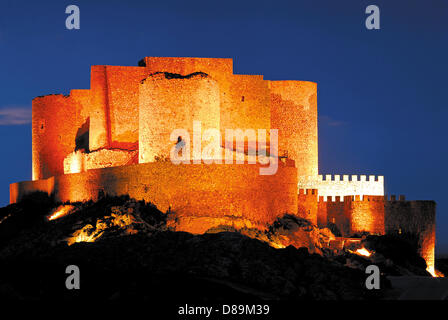 Das mittelalterliche Castillo von Consuegra steht zusammen mit den zehn Windmühlen auf einem Hügel hoch über der Stadt. Nachts erstrahlen sie alle zusammen im Scheinwerferlicht. Foto Stock