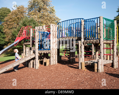 Bambini che giocano su un telaio di arrampicata e scorrere in area di gioco di Golders Hill Park, a nord ovest di Londra Foto Stock