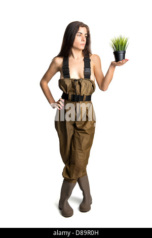 Ragazza in posa con un piccolo vaso con erba Foto Stock