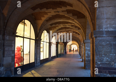 Eleganti gallerie d'arte la linea il porticato sul lato nord della storica Place des Vosges. Risalente1612 è la piazza più antica di Parigi. La Francia. Foto Stock