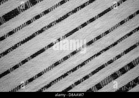 Un tessuto con strisce diagonali bianche e nere che creano un design audace e a contrasto elevato. La texture a righe aggiunge un look moderno e grafico al tessuto. Foto Stock